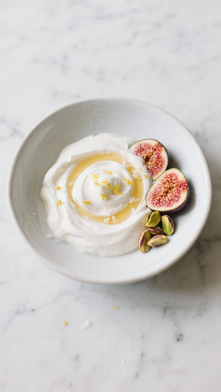 Final dish presentation: Beautifully plated thick Greek yogurt swirled into soft peaks in a matte wh